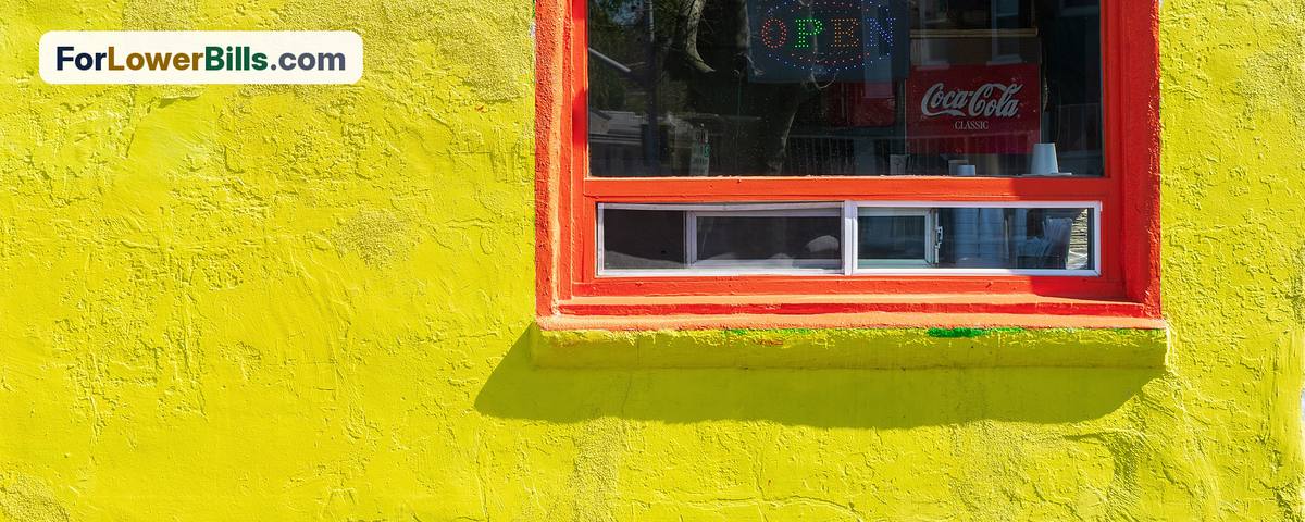 Small shop window with an Open sign on a bright yellow storefront