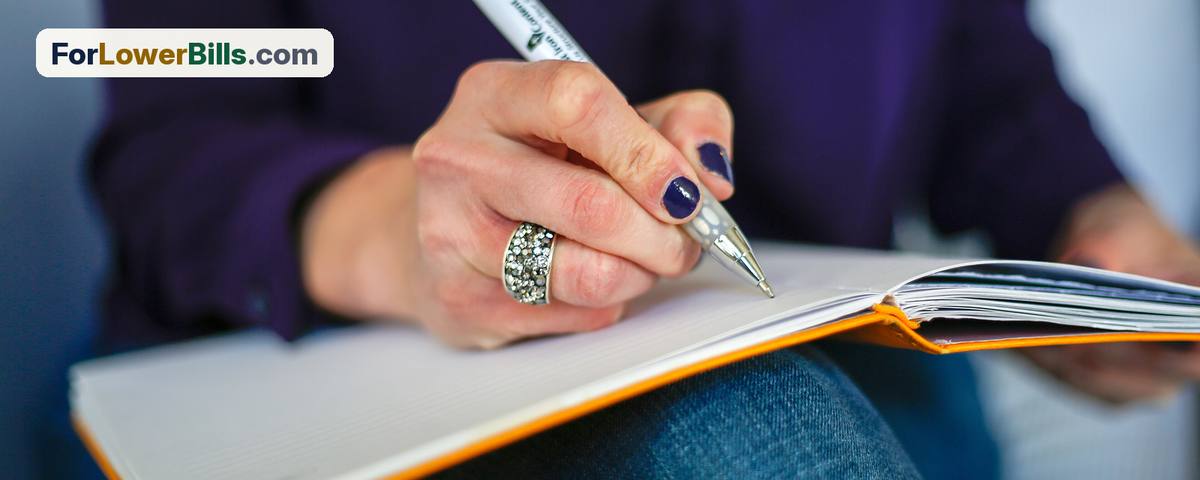 Person writing notes on a notepad with a pen