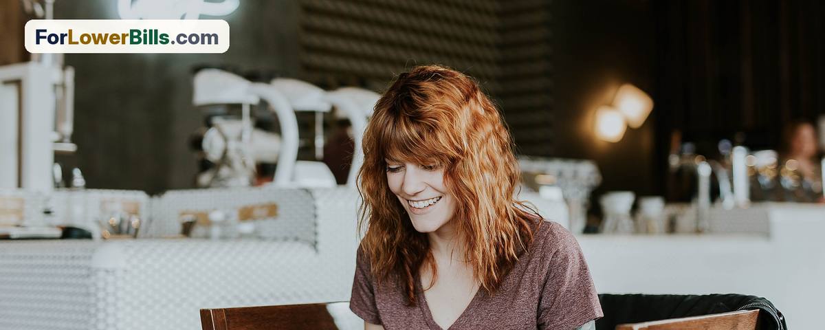 Smiling woman working on a laptop in a coffee shop in Arkansas