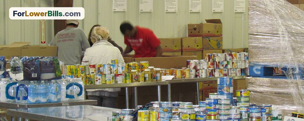 Volunteers sorting canned food and bottled water at a food bank warehouse