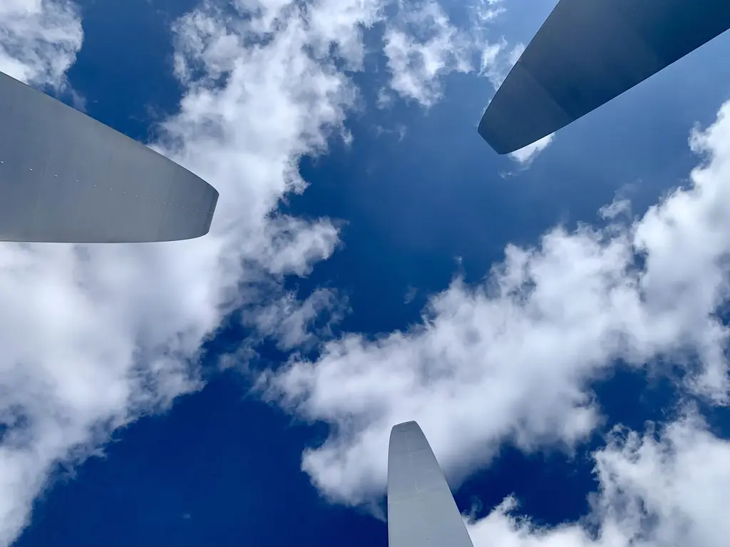 Looking up between the soaring steel spires of the U.S. Air Force Memorial into a blue sky with white clouds