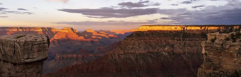 Panoramic view of the Grand Canyon South Rim glowing orange and red at sunset